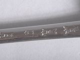 a silver spoon with writing on it sitting on a table