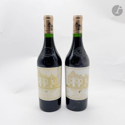 deux bouteilles de vin posées l'une à côté de l'autre sur une surface blanche