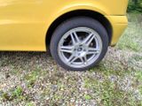a yellow car that is parked in the grass