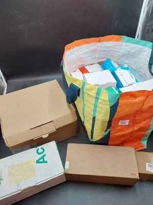 de nombreuses boîtes et un sac posés par terre à côté d'une chaise