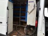 a white van with a blue door and a hose in the back of it
