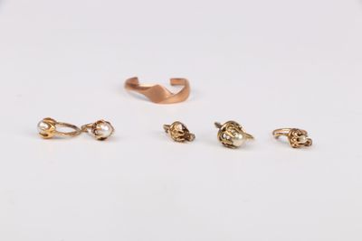 trois paires de boucles d'oreilles en or posées sur un fond blanc