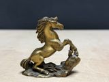 brass statue of a horse on a rock on a table