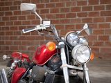 a red motorcycle that is parked in front of a brick wall
