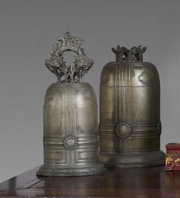 deux clochettes posées sur une table à côté d'un livre
