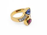 un gros plan d'une bague en or sertie de pierres bleues et roses