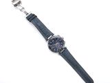 an image of a watch on a white surface with a blue strap