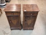 pair of antique wooden nightstands in a room with a pink chair