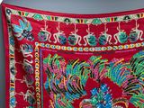 an image of a red cloth with a peacock design on it