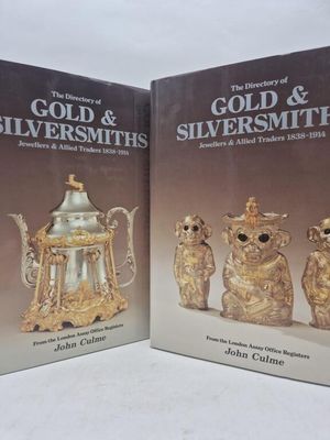 two books with gold and silversmiths on them sitting on a table