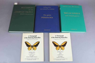 three books on a table with a butterfly on top of them
