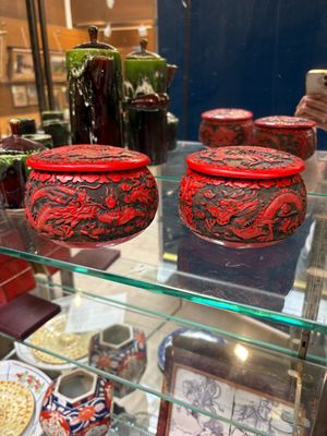 une vitrine en verre sur laquelle sont exposés de nombreux vases différents