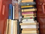 a red bin full of books sitting on the floor