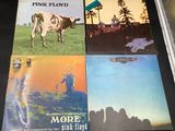 three pink floyd albums on a table with a cow and windmill in the background
