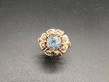 Gros plan sur une bague en or ornée d'une topaze bleue