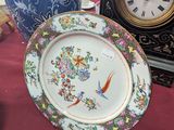 a plate that is sitting on a table with a clock in the background