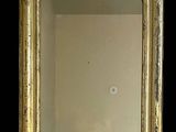 une image représentant un miroir à cadre doré accroché à un mur noir