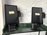 deux écrans d'ordinateur posés sur un bureau au plateau vert
