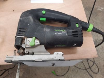 a black and green corded jig saw on a table