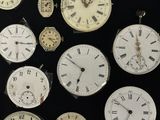 many different types of clocks displayed on a black surface