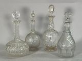 four clear glass bottles sitting next to each other on a white surface