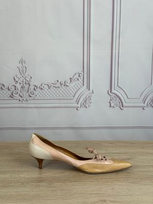 pair of women ' s shoes sitting on a wooden floor in front of a wall