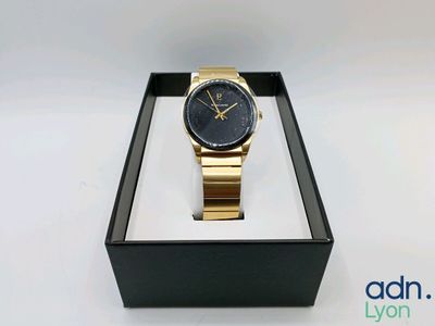 a close up of a watch in a box on a white surface
