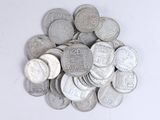 une pile de pièces d'argent posée sur une surface blanche