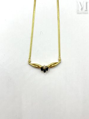 a gold plated necklace with black stones on a white background