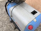 a machine that is sitting on the ground with a hose attached to it