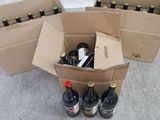 plusieurs bouteilles de vin dans un carton posé par terre