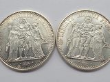 two silver coins, one of which is a woman and one of which is a man