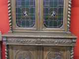 a wooden cabinet with two glass doors on top of it