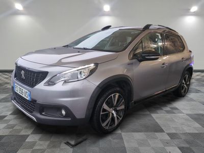une voiture argentée est garée dans une pièce au sol en damier