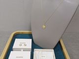 un collier, des boucles d'oreilles et des bijoux présentés dans une vitrine posée sur une table