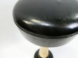 a black stool with a wooden base on a white surface