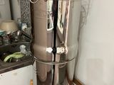 a large stainless steel water urn in the corner of a kitchen