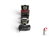 three cameras sitting on top of each other on a white surface