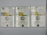 three silver coins are sitting on top of each other on a white surface