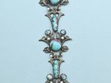 a close up of a necklace with a cross on it