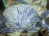 a close up of a blue and white vase with a bird on it