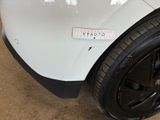 the rear end of a white car with a sticker on it