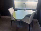 a table and chairs in a room with a window