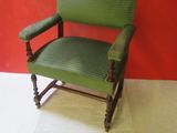 a green chair that is sitting in front of a red wall