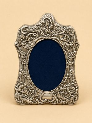 un cadre photo argenté avec un fond bleu sur une surface beige