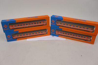 deux wagons orange et bleu placés côte à côte sur une surface blanche