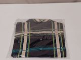 the shirt is wrapped in plastic and sitting on a white table