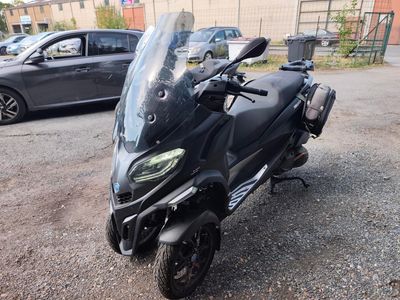 une moto noire garée sur un parking à côté d'une voiture noire