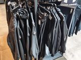 a lot of jackets hanging on a rack in a clothing store