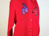 a red sweater with purple and blue butterflies on it
